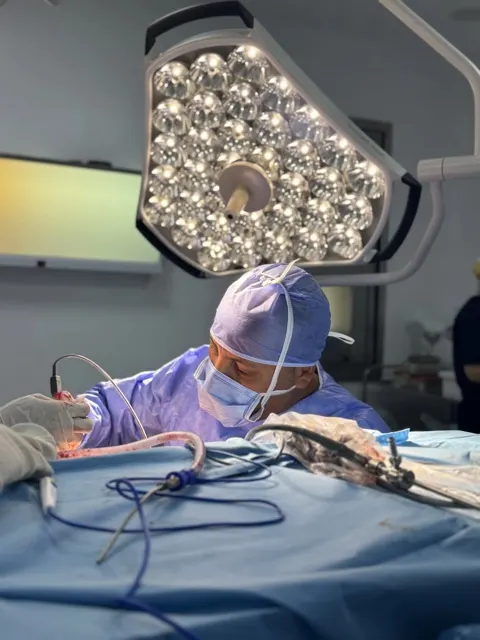 Geste chirurgical sous éclairage de bloc, reportage photo au bloc opératoire